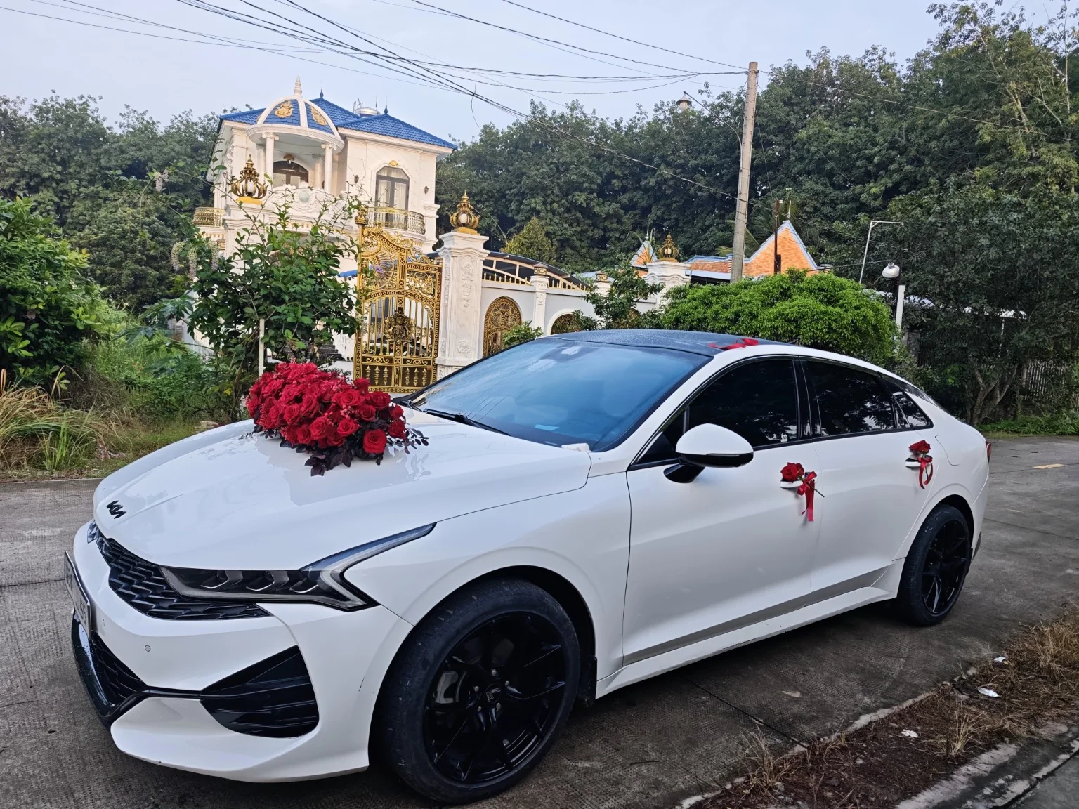 KIA K5 Premium 2.0 trắng trang trí hoa cưới góc chéo, ảnh xe thực tế